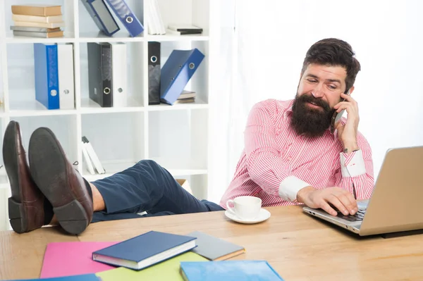 Comunicación empresarial. El barbudo habla por teléfono en la oficina. Comunicación con los clientes. Computadora y acceso a Internet. Usando tecnologías de comunicación. Comunicación del teléfono móvil. 3G. 4G —  Fotos de Stock