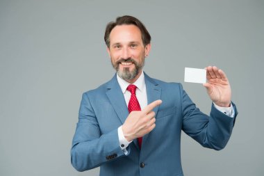 Resmi takım elbiseli profesyonel denetçi. Kendine güvenen erkek yönetici. Kopyalama alanı için yer. Ofis ceketli CEO banka kredi kartını gösteriyor. Olgun iş adamı kartvizitini tutar. Harika gün.