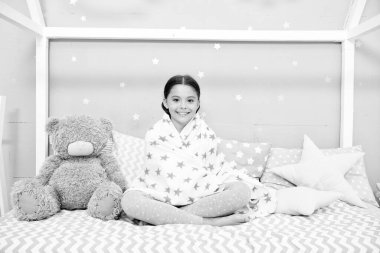 Evde iyi hissediyorum. Yatak odası derli toplu. Küçük bir kız için hoş bir yatak odası. Kız yatak odasının içinde eğleniyor. Çocukluk konsepti. Yatak odası dinlenme ve dinlenme yeri. Pijamalı çocuk. Mutlu sabahlar