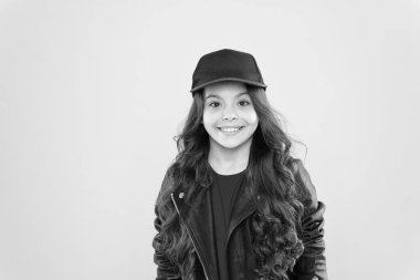 Havalı ve şık. Nasıl hippi olunur. Şık deri ceketli mutlu çocuk. Küçük kız şapka takıyor. Çocuk modası konsepti. Çocuğun uzun kıvırcık saçları var. Kuaföre git. Hip hop tarzında. Çok havalı görünüyorsun.