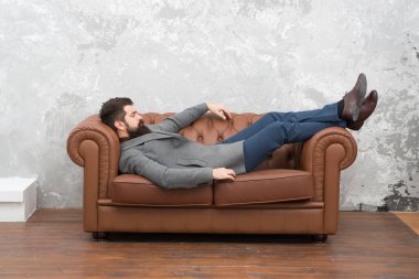 Uykuya daldı. Sakallı adam kanepede kestir. Hippi, elbise ve ayakkabı giyerek uyur. Şekerleme mi hayal mi? İş molası ve dinlenme. Uyku vakti. Yorgun ve yorgun olmak. Güzel bir yerde kısa bir uyku.