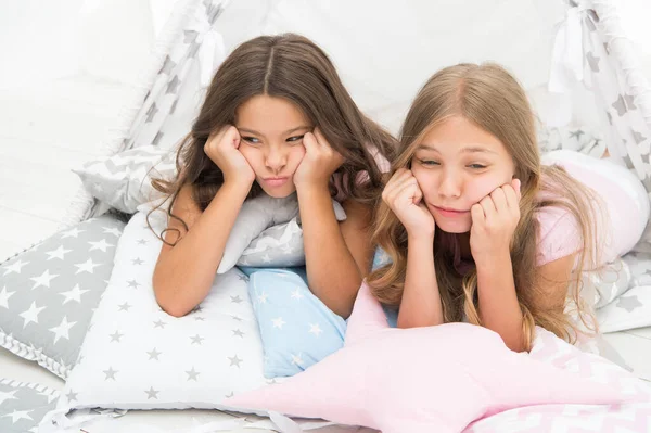 Bored kids on quarantine. Sisters best friends spend time together lay on pillows. Girls feeling sad. Girlish leisure. Sisters share gossips at home. Bored children. Boring activity. Tired and sleepy — Stock Photo, Image