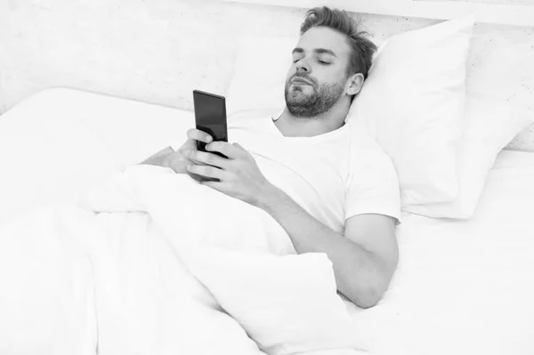 Vibraciones matutinas. todo el mundo en el teléfono. está blogueando. coqueteando y enviando mensajes de texto. adicción a Internet y concepto de abuso móvil. hombre en la cama charlando. hombre utilizar el teléfono inteligente desde la madrugada —  Fotos de Stock