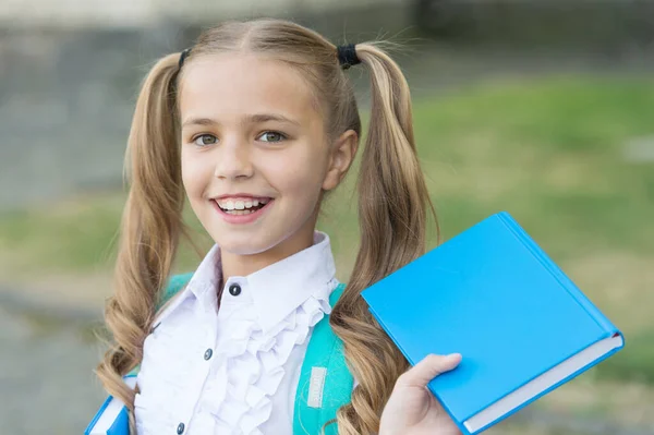 Boek is uniek draagbare magie. Gelukkig schoolmeisje houdt boek buiten. Kleine lezer. Schoolbibliotheek. Literatuurstudie. Leesgewoonte. Boekenwinkel. Onderwijs en kennis. Boek dat je niet kunt weerstaan — Stockfoto