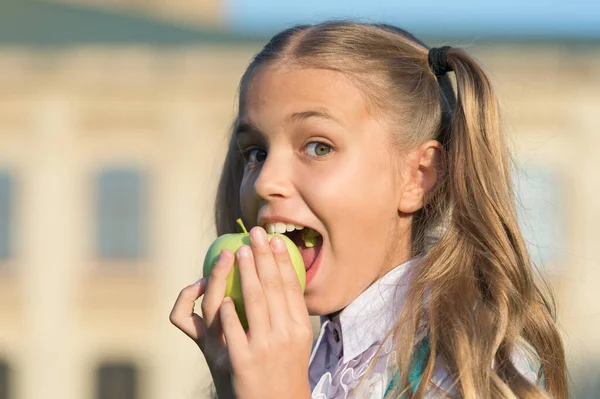 Eat for health. Happy child bite apple outdoors. Natural dieting. Dental health. Oral hygiene. Dental clinic. Dental care habits. Preventing cavities. Child care and health. Fruit for teeth health
