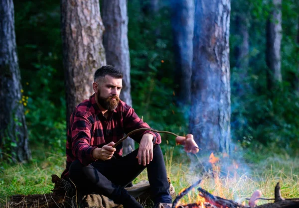 Homem, hipster, caminhante salsichas assadas em pau na fogueira — Fotografia de Stock