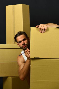 Karton kutuları etiketleyen endişeli yüzlü bir adam.