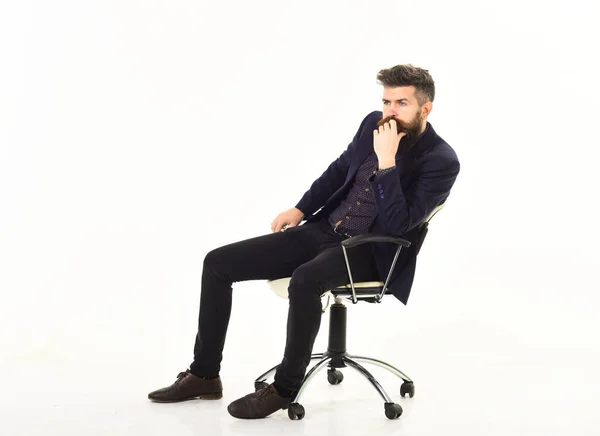 Бизнесмен сидит на офисном стуле с серьезным лицом — стоковое фото