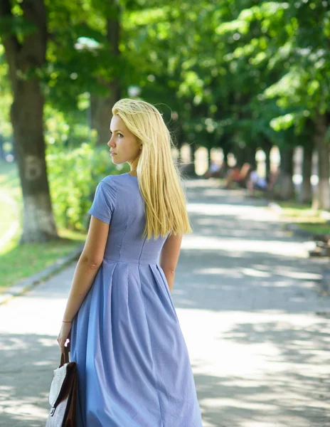 Menina com cabelo loiro longo usa vestido azul andando — Fotografia de Stock