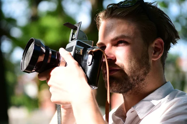 턱수염을 기르는 사람은 녹색 배경에 광 카메라를 들고 있다 — 스톡 사진