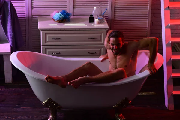 Macho sitzt nackt in Badewanne mit erotischer Atmosphäre herum — Stockfoto