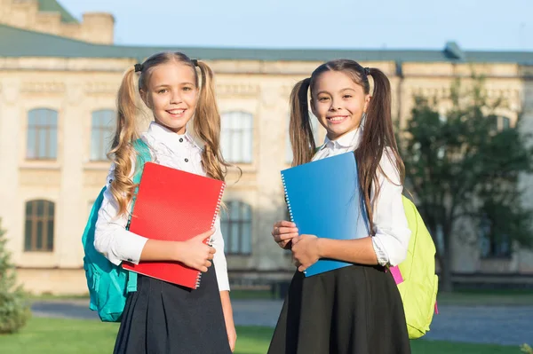 A amizade duplica as alegrias. Crianças felizes de volta à escola. As crianças têm livros ao ar livre. Amigos da escola gostam de amizade. Dia internacional da amizade. Ligações de amizade. Amigos da infância — Fotografia de Stock