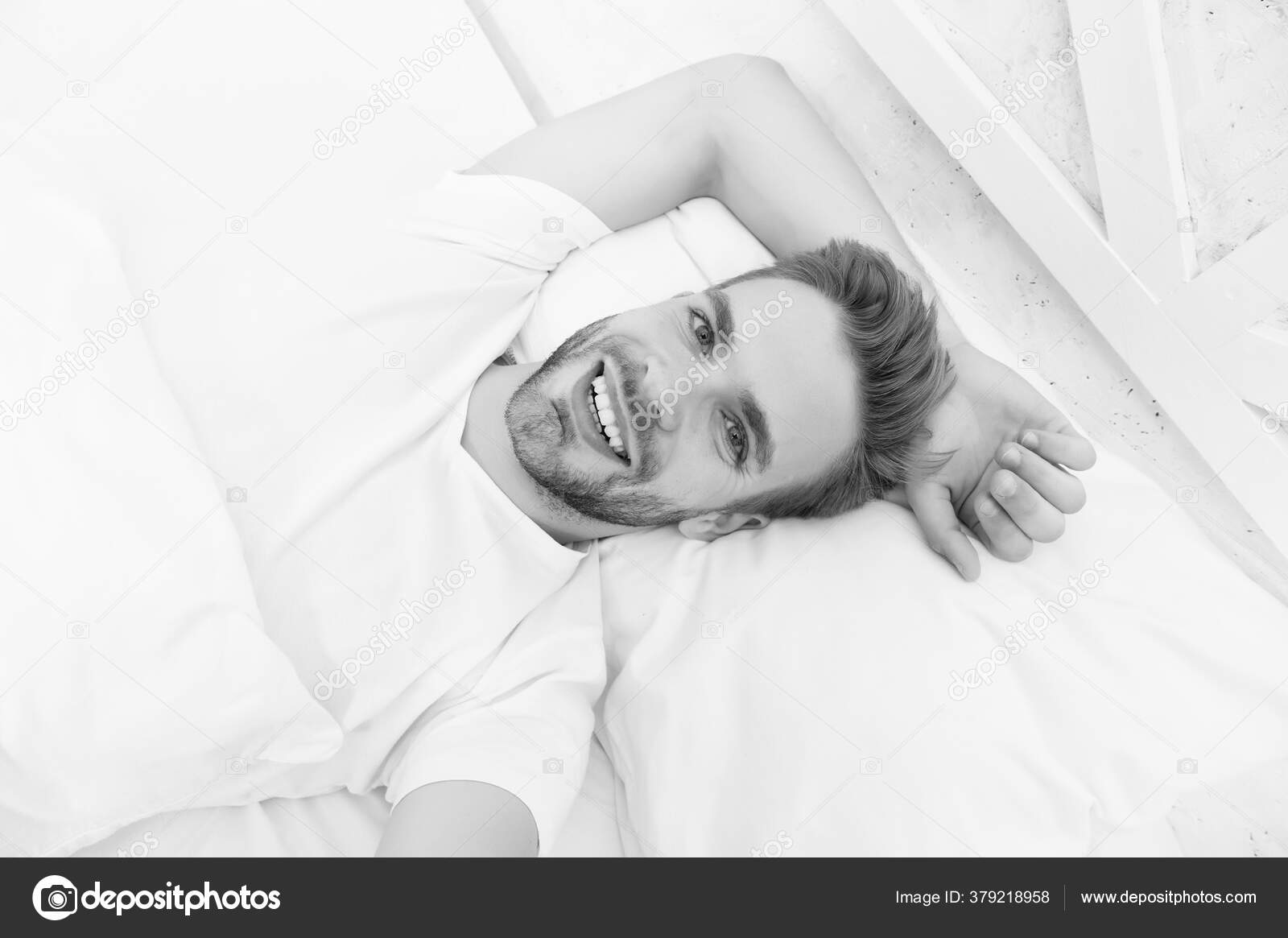 Handsome man relaxing in bed. Establish regular nightly sleep pattern