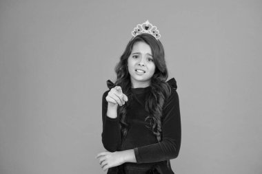 Sana demedim. Çocuk prensesin altın taç sembolünü takıyor. Tatlı bir bebek, taç giyer turuncu arka plan. Çocukluk konsepti. Prenses olmayı hayal eden kız. Küçük hanım prenses. Kamerayı işaret ediyor.