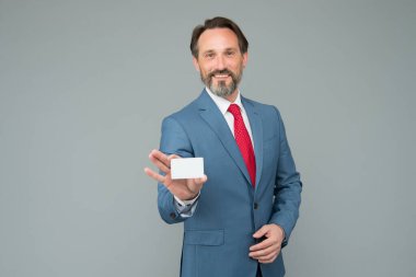 Olgun iş adamı kartvizitini tutar. Resmi takım elbiseli profesyonel denetçi. Kendine güvenen erkek yönetici. Kopyalama alanı için yer. Ofis ceketli CEO banka kredi kartını gösterdi