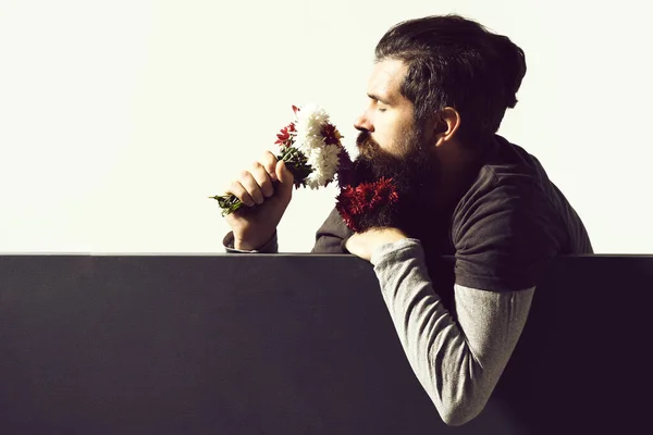 Hipster com flores em barba no fundo do estúdio cinza branco, espaço de cópia — Fotografia de Stock