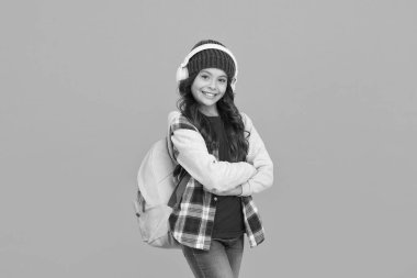 Heyecan ve zeka. Ses kursları. Öğrenme teknolojisi. Modern teknolojiler. Öğrenme yöntemleri. Okul kitabını dinliyorum. Liseli kız kablosuz kulaklık kullanıyor. Öğrenim teknolojileri