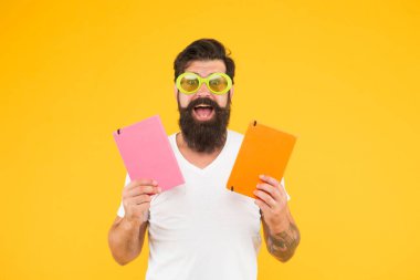 İlginç bir öğrenme. Öğrenmek eğlencelidir. Zevkle çalışıyorum. Eğlenmene bak. Mutlulukla öğreniyorum. Güneş gözlüklü komik, neşeli yetişkin adam kitap tutuyor. Üniversitede okuyorum. Pozitif ve enerjik