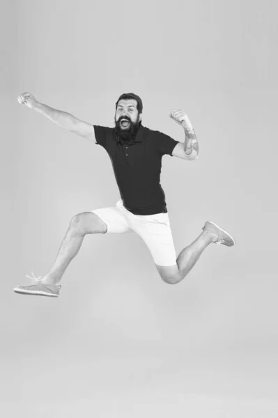 Healthy guy feeling good. Inspired concept. Towards fun. Enjoying active lifestyle. Happy guy jumping. Active bearded man in motion yellow background. Active and energetic hipster. Energy charge — Stock Photo, Image