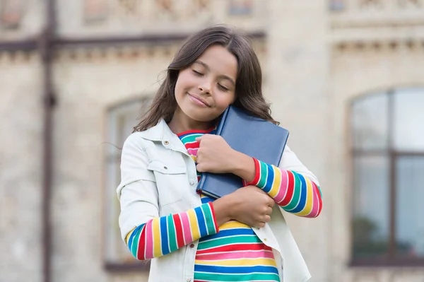 Autor favorito. Ser responsável por devolver livros a tempo pode ensinar algumas noções básicas de responsabilidade. Conceito de conhecimento. Uma menina segura o livro. Menina com fundo urbano livro. Livro da biblioteca — Fotografia de Stock