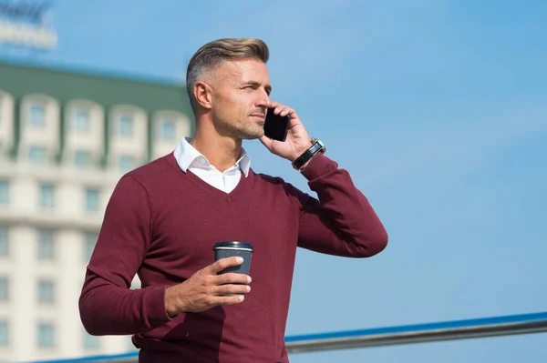 Ahoj. Hezký muž mluví po telefonu a pije kávu venku. Odpovídám na telefonát. Přímý marketing prostřednictvím mobilního telefonu. Připojení na mobil. Obchodní sdělení. Nová technologie. Moderní život — Stock fotografie