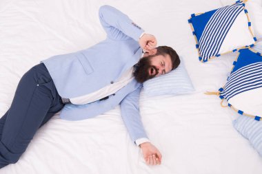 İş hayatı asla uyumaz. Sakallı adam iş elbisesi içinde esniyor. Hippi yatakta yatıyor. Şık bir iş elbisesi. Formalite ve iş kıyafetleri. Moda ve tarz. Erkek giyim mağazası