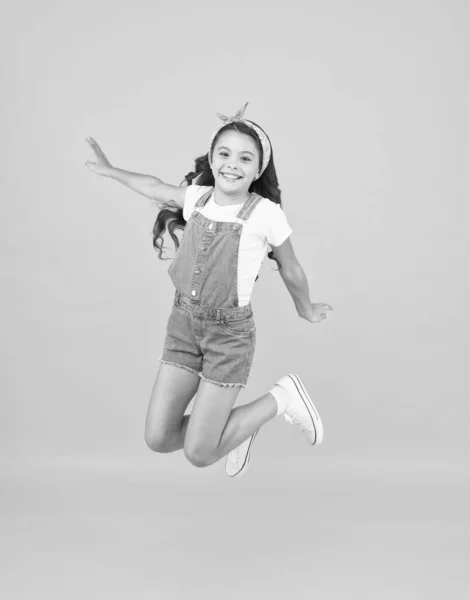 Sprung des Glücks. kleines Mädchen springen gelben Hintergrund. voller Energie. aktive Mädchen fühlen Freiheit. Spaß und Entspannung. Sich frei fühlen. Sorgenfreies Kind im Sommerurlaub. Zeit für Spaß. Retro-Schönheit in der Luft — Stockfoto