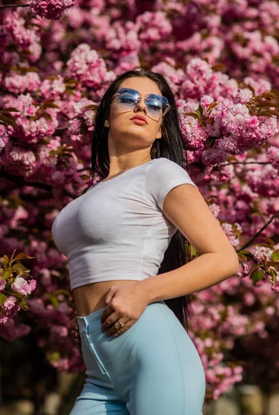 Sakura, kiraz çiçeği ağacı. Seksi kız sakura çiçeğinin tadını çıkarıyor. Kiraz çiçekli kadın. Çiçekli güzel bayan. Doğa Saç Tarzı. Tatil Moda Makyajı. Yaz romantik imajı — Stok fotoğraf