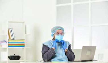 uzaktan çalışma konsepti. Sıhhi doktor üniformalı bir adam. Adam solunum maskesi, eldiven ve koruyucu gözlük takıyor. Evde güvende kal. Koronavirüs salgını. Hijyen kilitlendi.