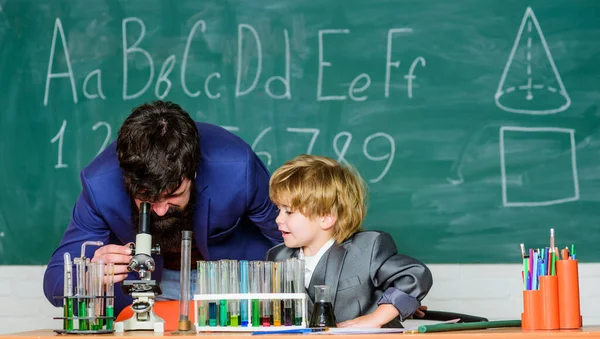 Lärare man med liten pojke. En vetenskapsman som studerar naturvetenskap. Små barn lär sig kemi i skolans laboratorium. Tillbaka till skolan. far och son i skolan. Du tänjer på gränserna. Er värld — Stockfoto