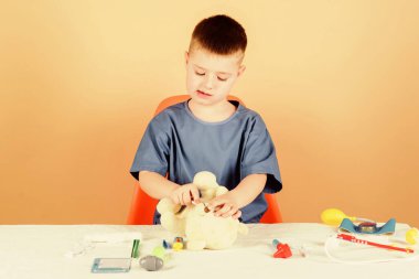 oyuncak tedavisi. Tedavi reçetesi. Çocuk doktoru stajyeri. Tıp üniformalı küçük bir çocuk. Hastane. İlaç ve sağlık. Hemşire laboratuvar asistanı. Aile doktoru. Steteskoplu çocuk doktoru.