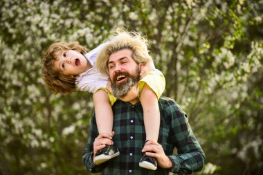 Aileyle hafta sonu. Mutlu aile günleri. Bahar geliyor. Eğlenmene bak. Aşk konsepti. Baba parkta çocuğuyla oynuyor. Yakışıklı bir baba ve tatlı bir oğlu var. Çiçek ve doğanın tadını birlikte çıkarın.
