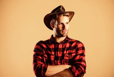 Vahşi batı rodeosu. Şapkalı yakışıklı adam. Kırsal kesimdeki kovboy. Batı. Çiftlikte kareli gömlek. Klasik tarz adam. Vahşi Batı eski kovboy. Batı kovboy portresi