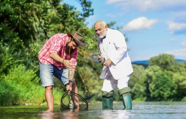 Biz bir aileyiz. Yakalama ve balık tutma konsepti. Emekli baba ve olgun sakallı oğul. Mutlu balıkçı arkadaşlığı. İki erkek arkadaş birlikte balık tutuyor. İş adamının uçan balık hobisi. emeklilik balıkçılığı