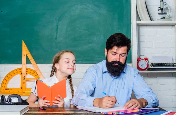 La lección está terminada. Hombre barbudo pedagogo estudio junto con el niño. El estudio es divertido. Profesora de escuela y colegiala. Tarea realizada con éxito. Educar en casa con padre. Ayuda a estudiar. Enseñanza disciplinaria —  Fotos de Stock