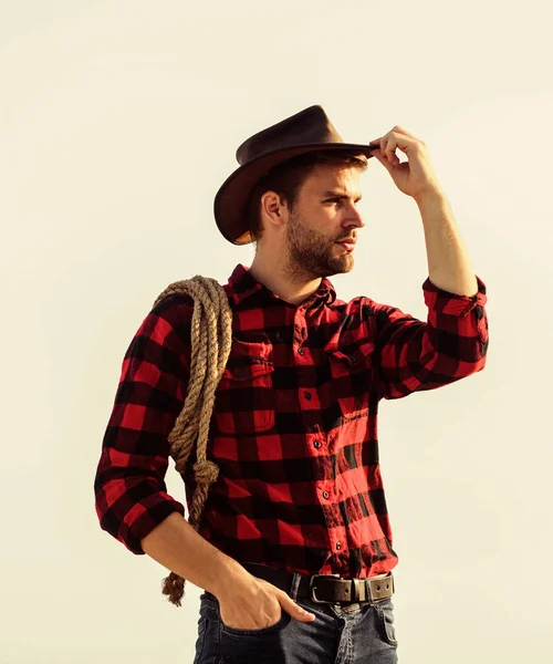 Trabalhador do rancho. A vida no rancho. Cowboy com fundo do céu corda laço. Eco fazenda. Conceito de agricultura. Homem bonito de chapéu e roupa de estilo rústico. Fica com o rancho. Agricultor atencioso pensando em negócios — Fotografia de Stock