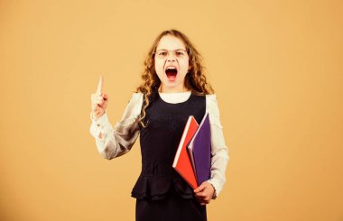 Stresli küçük kız öğretmen olmak istiyor. Günlük notları için not defteri. Ders çalışmak. Bilgi ve eğitim. Okula dönelim. Ev ödevi. Kağıt klasörlü küçük bir kız. İnanılır gibi değil. Hayır.