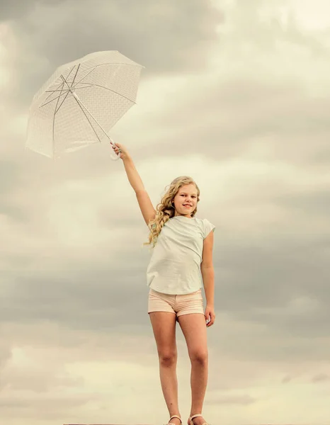 天気が変わる。新鮮な空気だ。傘の曇った空の背景を持つ女の子。自由と新鮮さ。反重力の概念。楽しみ方だ。屋外で気をつけて。天気予報。どんな天気でもいい — ストック写真