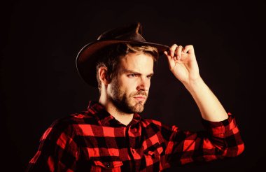 Masculinity and brutality concept. Archetypal image of Americans abroad. Cowboy life came to be highly romanticized. Adopt cowboy mannerisms as a fashion pose. Man unshaven cowboy black background clipart