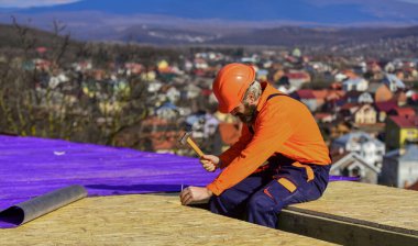 Roofer yeni çatı yapıyor. Çatı ustası yüzeyi. Profesyonel tamir çatısı. Düz çatı kurulumu. İnşaat binası. Su geçirmez çarşaf. Yüksek irtifa işe yarıyor. Isı yalıtımı