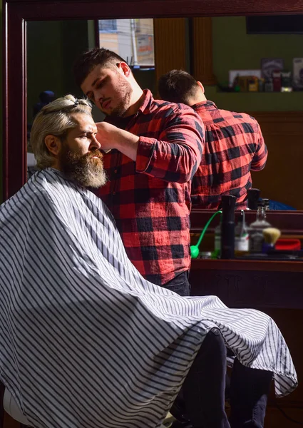 L'oggetto affilato vicino a faccia e contorcersi distrae la persona che lo tiene. Dona i capelli. Concetto di donazione e carità. Un tizio con i capelli biondi tinti. Taglia i capelli. Barbiere parrucchiere. Hipster ottenere taglio di capelli — Foto Stock