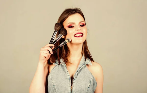 Kosmetikkonzept Make-up. Betonung der Weiblichkeit. Mädchen tragen Lidschatten auf. Hautpflege. Sieht gut aus und ist zuversichtlich. Frau schminkt Pinsel. Professionelles Make-up. Verschiedene Pinsel — Stockfoto