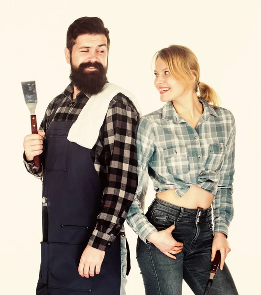 Hipster barbudo e menina segurar utensílios de cozinha grelhar fundo branco. Piquenique e churrasco. Festa de churrasco no quintal. Cozinhar juntos. Pratos de churrasco essenciais. Família se preparando para churrasco — Fotografia de Stock