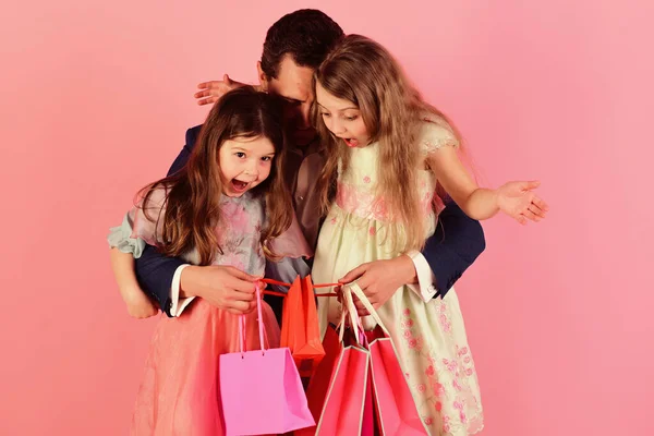 Shopping och presenterar konceptet. Flickor och man med förvånade ansikten — Stockfoto