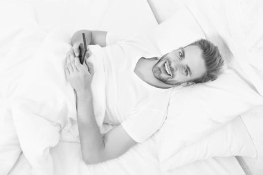 Telefon bağımlılığı tüyoları. Blog yazıyor. Flört ediyor ve mesaj yolluyor. İnternet bağımlılığı ve mobil taciz. Adam yatakta sohbet ediyor. Sabahtan beri akıllı telefon kullanıyor. Telefondaki tüm dünya