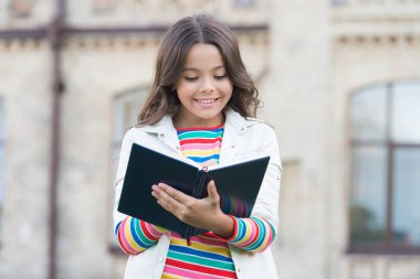 Küçük kız kitabı tutuyor. Kitap okulu geçmişi olan bir kız. Kütüphaneden kitap. Not alıyorum. İlham verici bir şair. Yetenekli tatlı kız öğrenci. Kitaptan çok daha fazlasına erişim. Bilgi kavramı