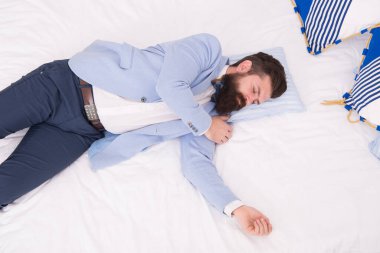 Modaya uygun kıyafetlerle uyumak. İyileşme ve şarj olma. Yorgun ve uykulu hissediyorum. Resmi giysiler içinde uykulu bir adam. Üst yatak manzaralı. Uykusuzluk. Biraz daha uyumam lazım. Akşam vakti. İşadamı yorgun.