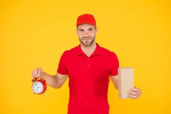 Shipping services. Post office. Online shopping. Will deliver at agreed time. Timeliness guarantee. Promptness and punctuality. Delivery time. Delivery courier with clock. Delivery man holding clock