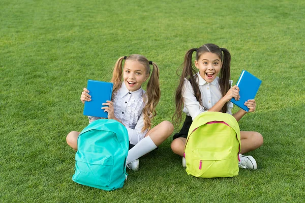 Books are best friends. Happy kids hold books outdoors. Adorable bookworms on green grass. School library. Literature and language. English grammar. Education and knowledge. Books about friendship