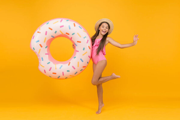 Summer resort. Recreation concept. Hotel with swimming pool. Little girl and swimming donut ring. Kid in swimsuit relaxing and having fun. Summer vacation. Cheerful kid relaxing. Relaxing at pool